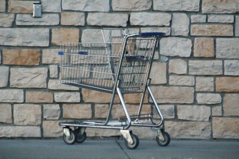 Empty shopping cart left against a stone wall