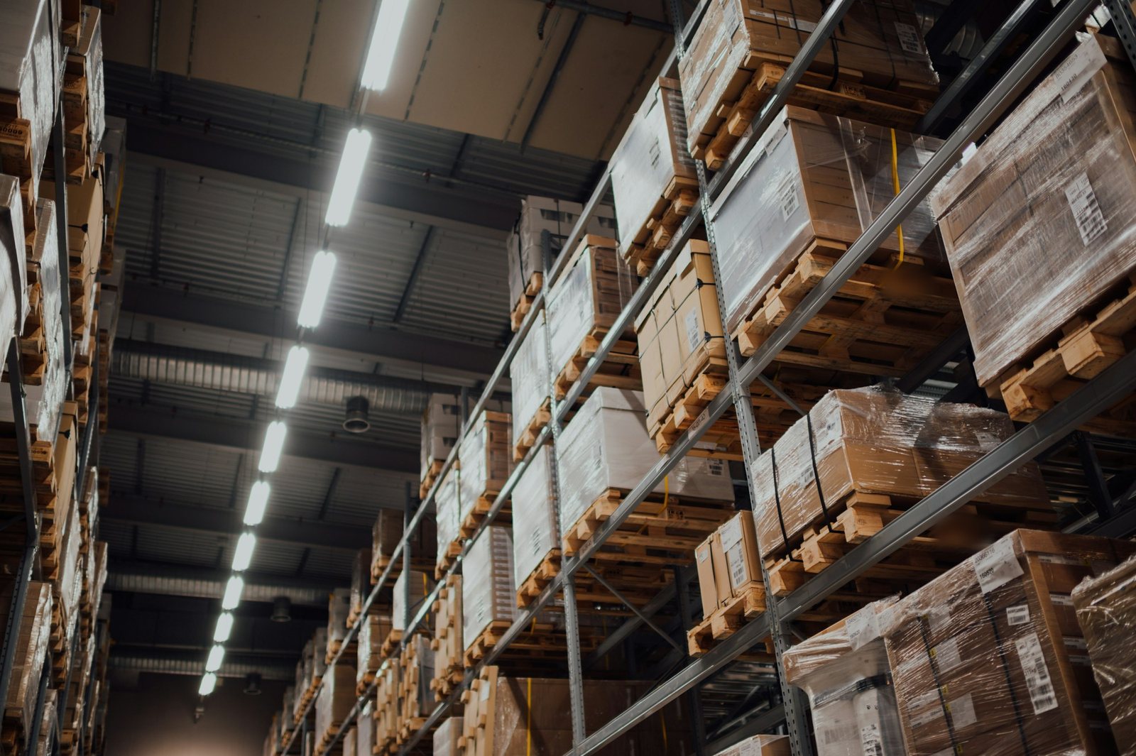 Tall warehouse racks stacked with wrapped boxes on pallets