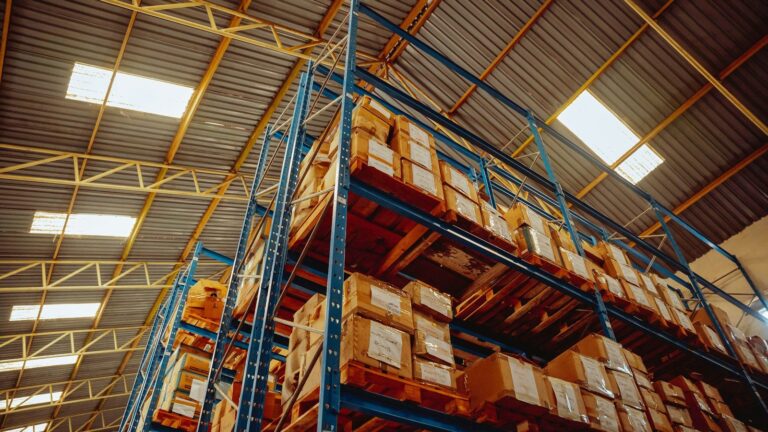 Tall warehouse racks full of boxed stock on pallets