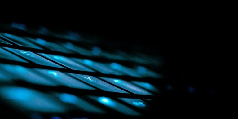 Close-up of a backlit keyboard in blue light with shallow focus